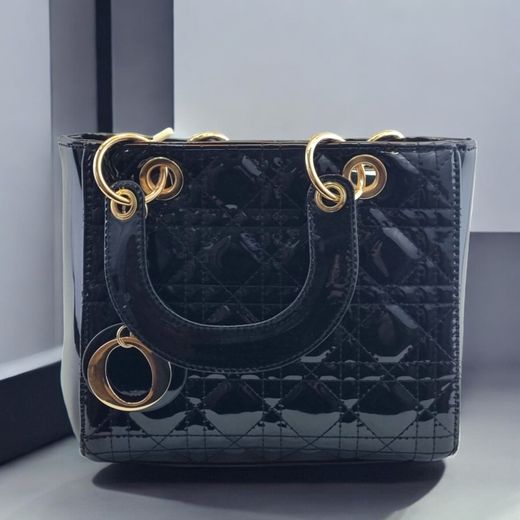 Bolso de mano clásico negro con acabado brillante y detalles dorados