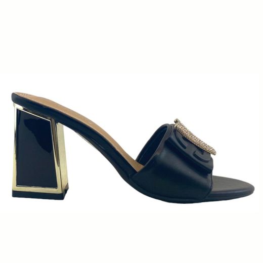 Mules elegantes negros con tacón medio y adorno metálico.